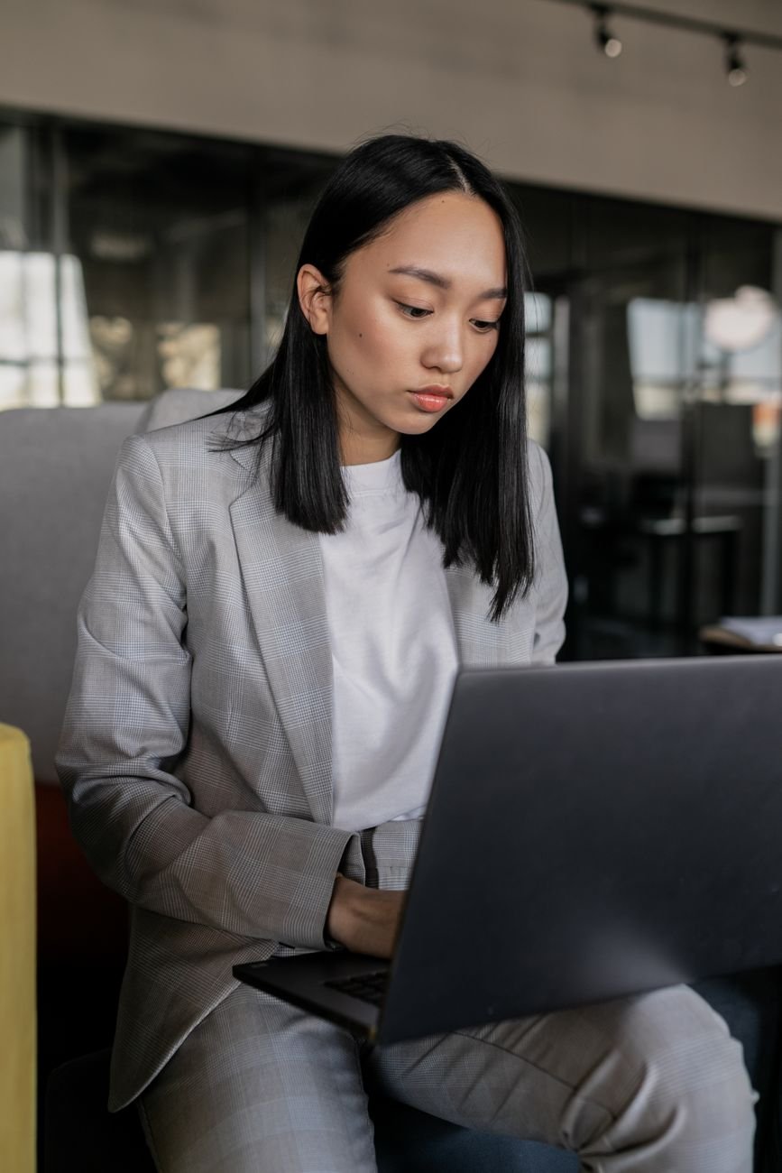 Focused professional working on laptop in a modern office setting.